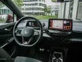 Wnętrze Volkswagena ID.4 GTX z ekranem nawigacji i cyfrowym kokpitem. Kierownica z przyciskami i oznaczeniem GTX.