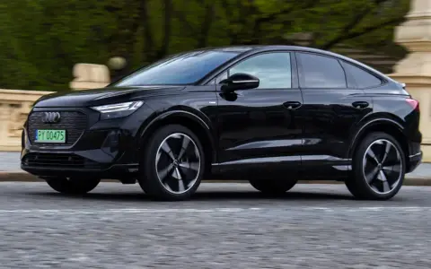 Czarny Audi Q4 e-tron w ruchu. Sprawdź, jaki jest jego zasięg na jednym ładowaniu.