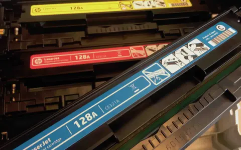 W drukarce widoczne są wkłady z tonerem: żółty, czerwony i niebieski. Niebieski wkład ma oznaczenie kod odpadu 160214.