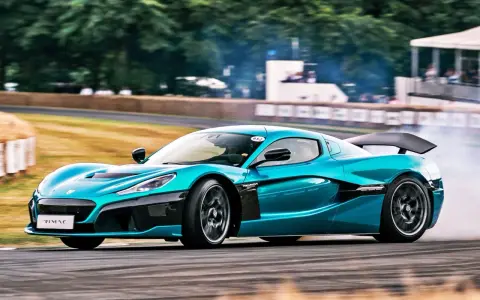 Niebieski Rimac Nevera, najszybsze auto elektryczne, driftuje na torze, wzbijając tumany dymu.