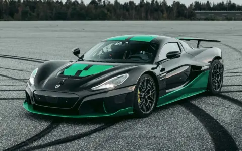 Czarny Rimac Nevera R z zielonymi akcentami na masce i progach, gotowy do jazdy po torze.