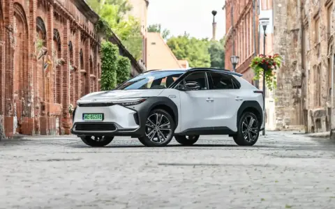Biała Toyota bZ4X na brukowanej uliczce, gotowa na długie podróże. Sprawdź jej imponujący zasięg!