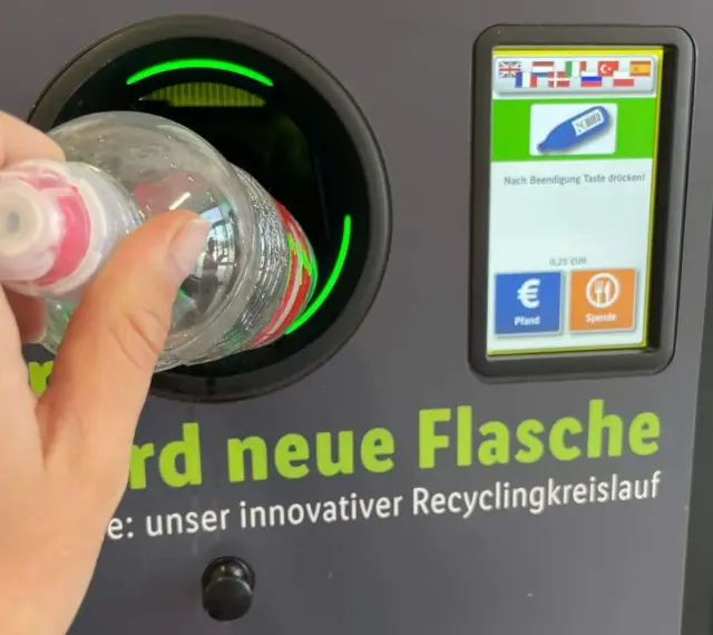 Ręka wrzuca butelkę do automatu. Niemiecki system kaucyjny działa sprawnie, zwracając 0,25 EUR za każdy zwrot.