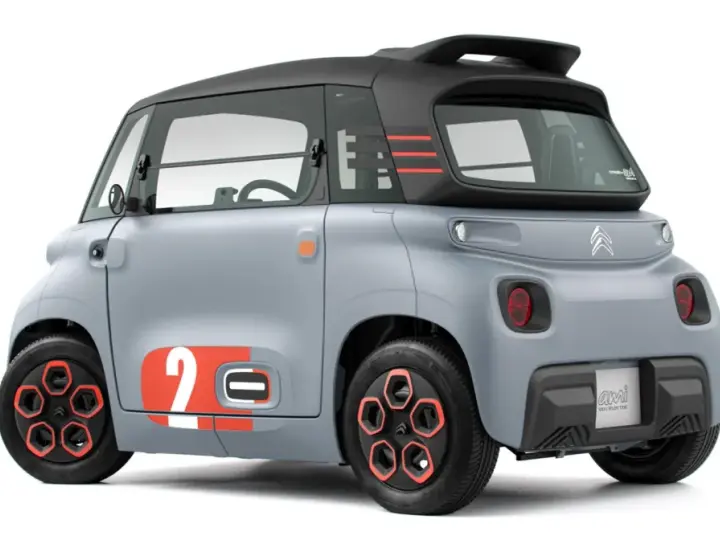 Szary Citroen Ami z pomarańczowymi akcentami i numerem 2. Ten elektryczny pojazd oferuje zaskakujący zasięg na jednym ładowaniu.
