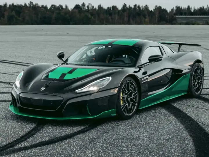 Czarny Rimac Nevera R z zielonymi akcentami na masce i progach, gotowy do jazdy po torze.