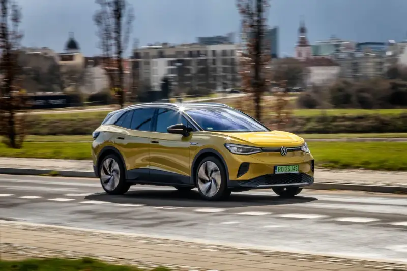 Żółty VW ID.4 jedzie po mieście, pokazując swój imponujący zasięg.